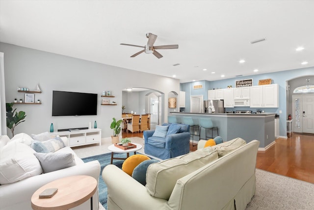 living room with ceiling fan and light hardwood / wood-style flooring