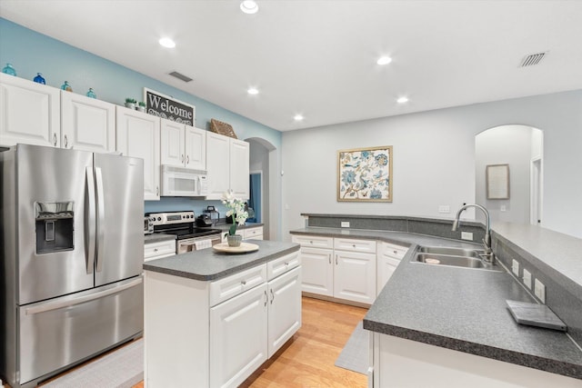 kitchen featuring light hardwood / wood-style floors, appliances with stainless steel finishes, sink, white cabinets, and kitchen peninsula