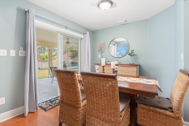 dining area featuring hardwood / wood-style flooring and a textured ceiling