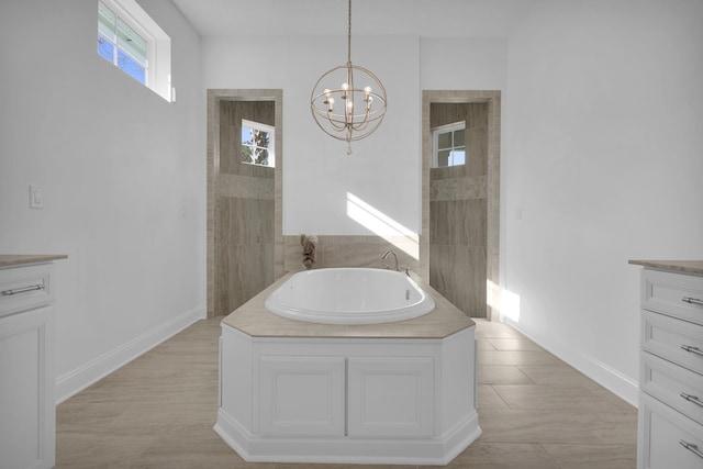 200 Manuel Ct, Saint Augustine, FL 32095 - bathroom featuring a notable chandelier, baseboards, vanity, and a garden tub