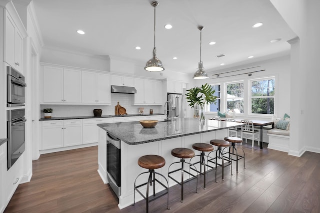200 Manuel Ct, Saint Augustine, FL 32095 - kitchen featuring under cabinet range hood, decorative backsplash, dark wood-style floors, and white cabinets