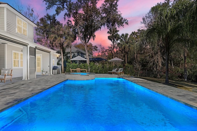 200 Manuel Ct, Saint Augustine, FL 32095 - pool at dusk featuring a patio area, an outdoor pool, an in ground hot tub, and grilling area