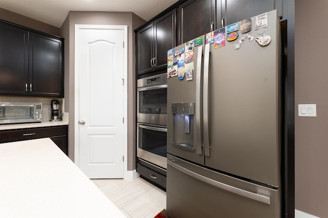 kitchen with dark brown cabinetry and appliances with stainless steel finishes