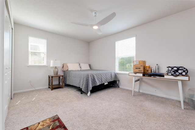 carpeted bedroom with ceiling fan and multiple windows