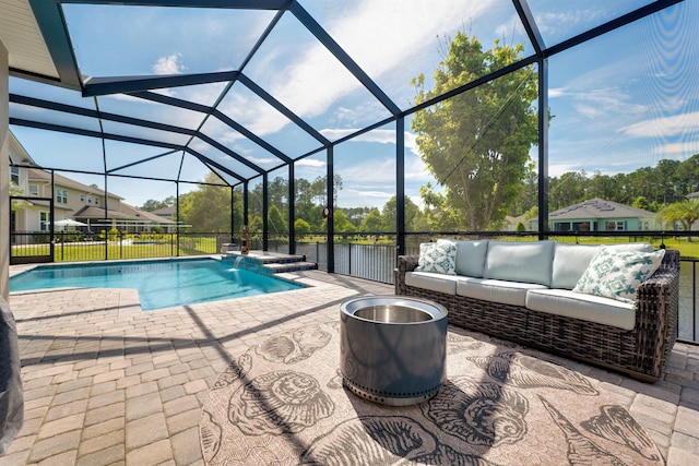 view of pool featuring pool water feature, an outdoor living space, a patio, and glass enclosure