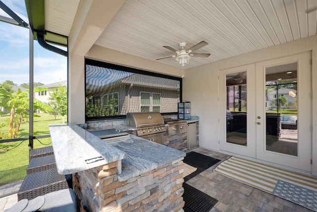 view of patio / terrace with french doors, exterior kitchen, ceiling fan, area for grilling, and a bar