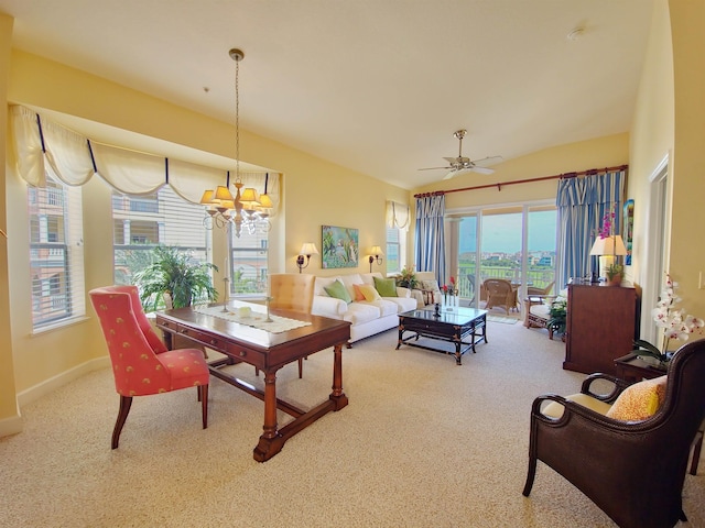 dining space with carpet, ceiling fan with notable chandelier, and plenty of natural light