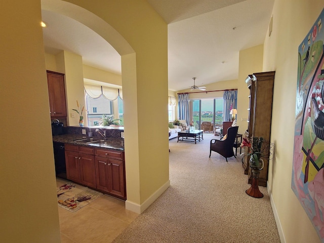 hallway with sink, lofted ceiling, and light carpet