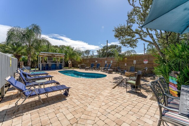 view of pool with exterior bar and a patio