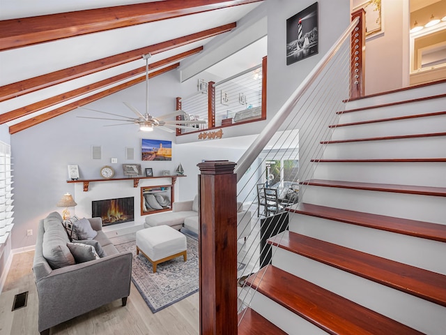 living room featuring vaulted ceiling with beams, ceiling fan, and light hardwood / wood-style floors