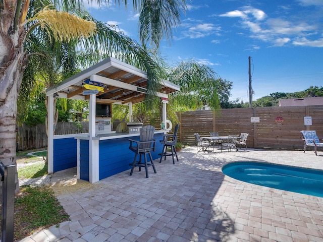 view of pool featuring a bar, area for grilling, a patio area, and a gazebo