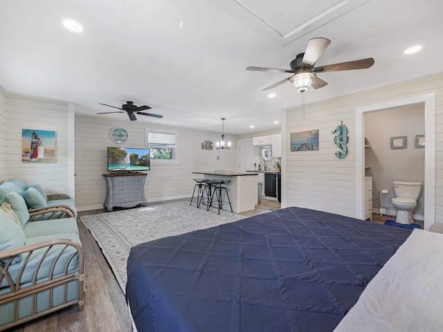 bedroom with ceiling fan, wood-type flooring, and connected bathroom