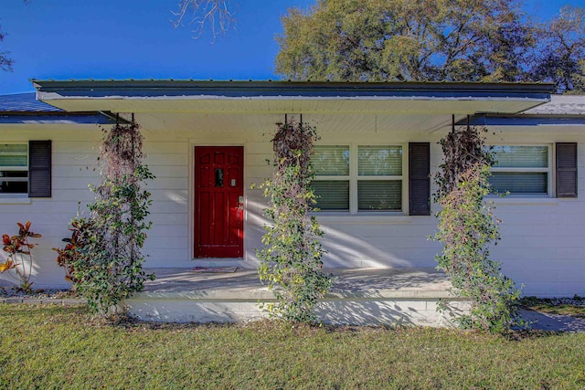 view of exterior entry featuring covered porch