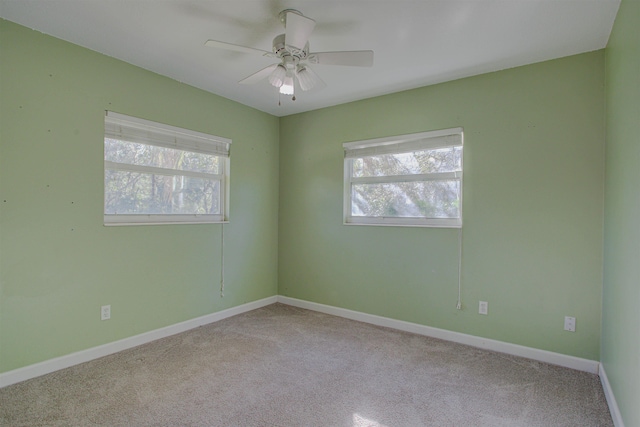 carpeted empty room featuring a wealth of natural light and ceiling fan