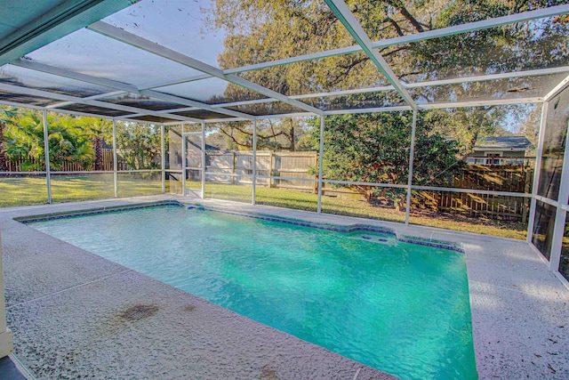 view of swimming pool featuring a lanai, a lawn, and a patio