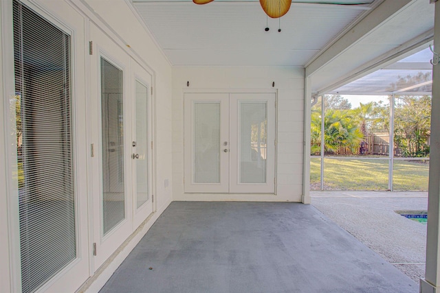 unfurnished sunroom featuring ceiling fan and french doors