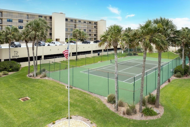 view of tennis court featuring a yard