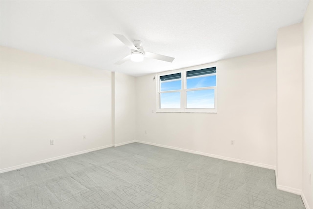 spare room with light colored carpet and ceiling fan