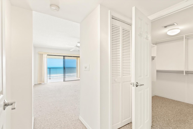 hallway featuring light colored carpet