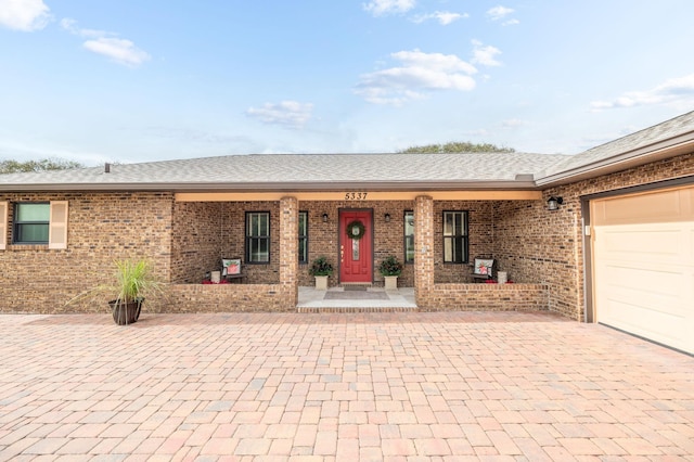 ranch-style home featuring a porch and a garage