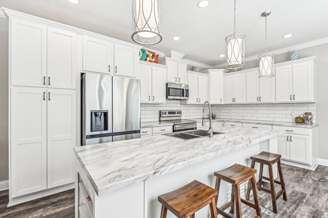 4954 A1A, Saint Augustine, FL 32080 - kitchen with stainless steel appliances, a sink, dark wood-style flooring, ornamental molding, and white cabinetry