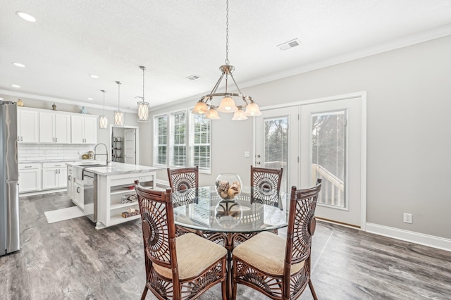 4954 A1A, Saint Augustine, FL 32080 - dining area with wood finished floors, a chandelier, ornamental molding, baseboards, and recessed lighting