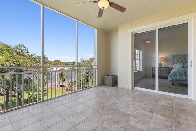 unfurnished sunroom featuring ceiling fan