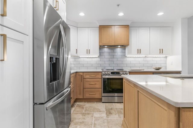 kitchen featuring tasteful backsplash, light countertops, appliances with stainless steel finishes, white cabinets, and under cabinet range hood