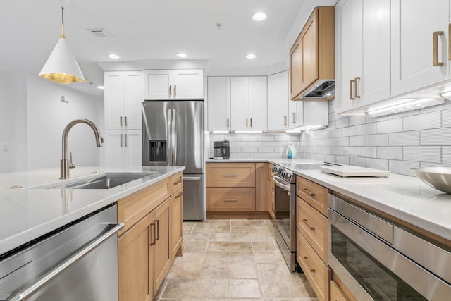 kitchen with stone tile floors, stainless steel appliances, a sink, visible vents, and tasteful backsplash