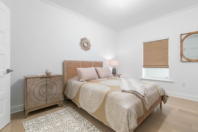 bedroom with ornamental molding, wood finished floors, and baseboards