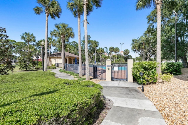 surrounding community featuring a yard, fence, and a gate