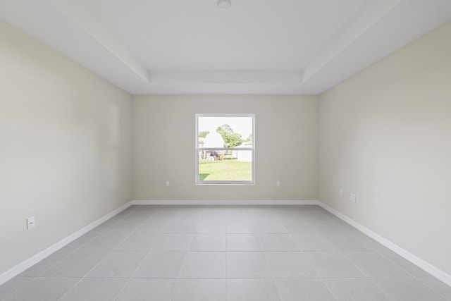 53 Pine Crest Ln, Palm Coast, FL 32164 - empty room with a raised ceiling, light tile patterned flooring, and baseboards