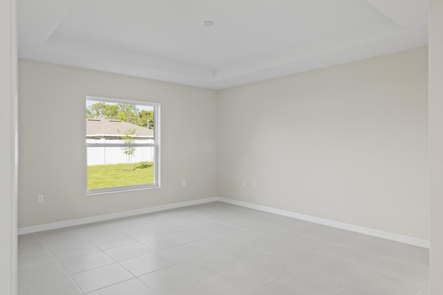 53 Pine Crest Ln, Palm Coast, FL 32164 - empty room with a tray ceiling, baseboards, and light tile patterned floors