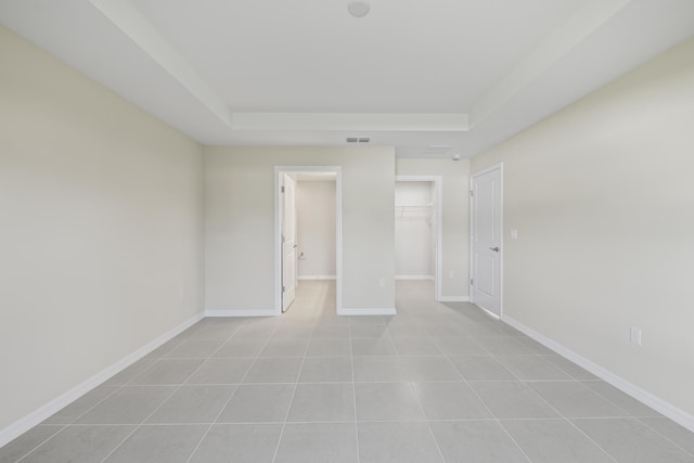 53 Pine Crest Ln, Palm Coast, FL 32164 - empty room featuring a tray ceiling, baseboards, and light tile patterned floors