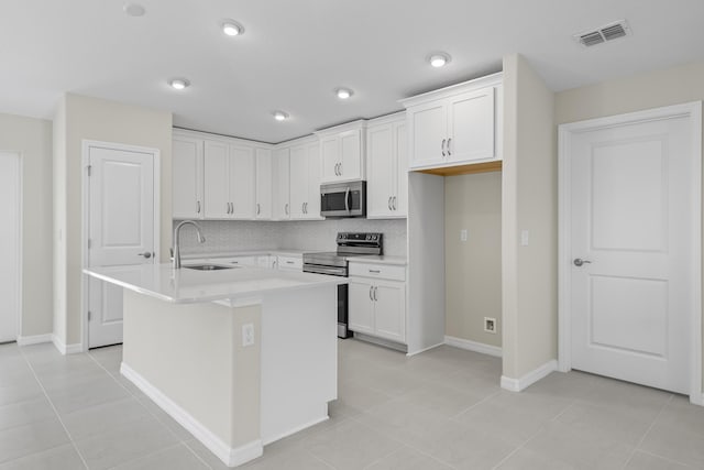 53 Pine Crest Ln, Palm Coast, FL 32164 - kitchen with stainless steel appliances, a sink, white cabinets, and light countertops