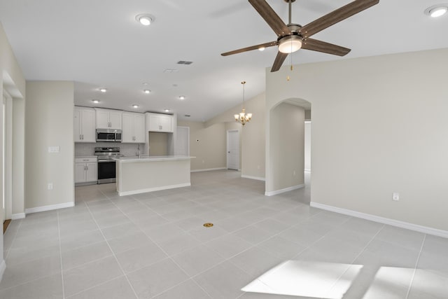 53 Pine Crest Ln, Palm Coast, FL 32164 - unfurnished living room with ceiling fan, lofted ceiling, arched walkways, light tile patterned floors, and baseboards