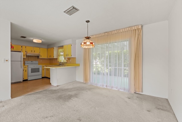 kitchen featuring white appliances, light countertops, light carpet, a sink, and decorative light fixtures