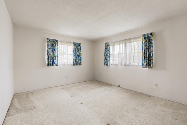 carpeted spare room with a textured ceiling