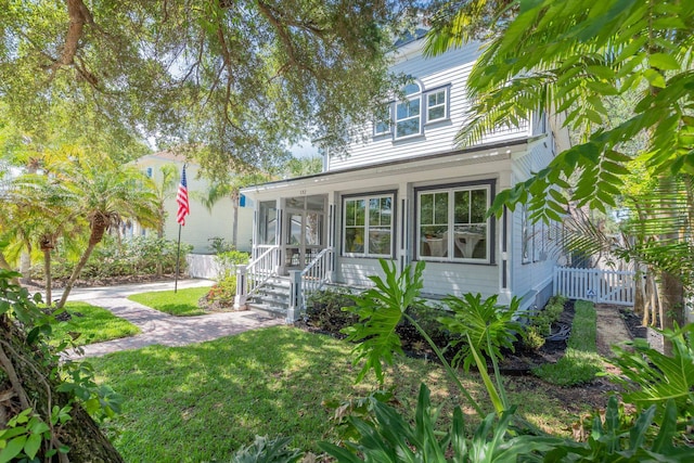 view of front of property featuring a sunroom and a front yard