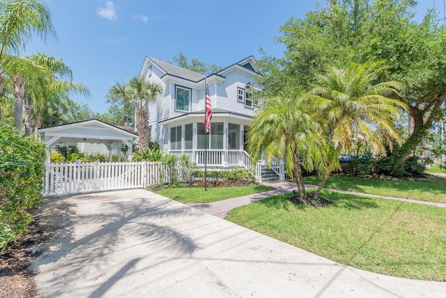 view of front of house with a front yard and a sunroom