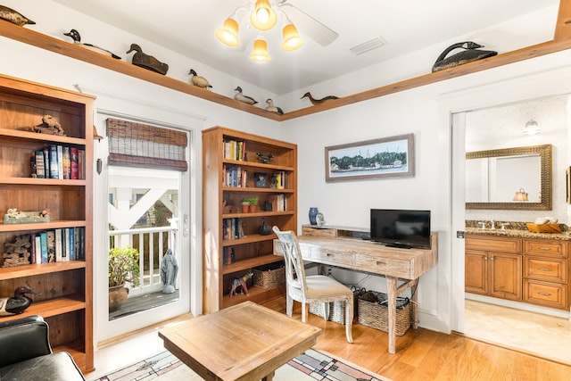 home office featuring light hardwood / wood-style floors and sink