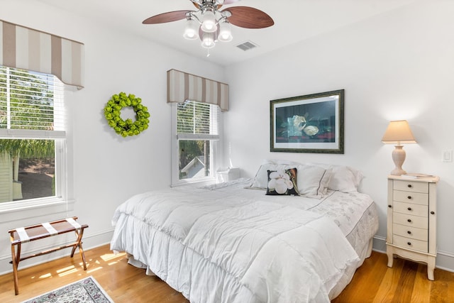 bedroom featuring hardwood / wood-style floors, multiple windows, and ceiling fan