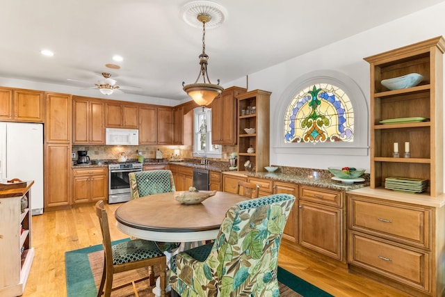 kitchen with sink, hanging light fixtures, ceiling fan, appliances with stainless steel finishes, and light hardwood / wood-style floors