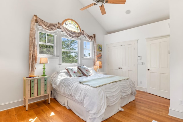 bedroom with a closet, ceiling fan, light hardwood / wood-style flooring, and lofted ceiling