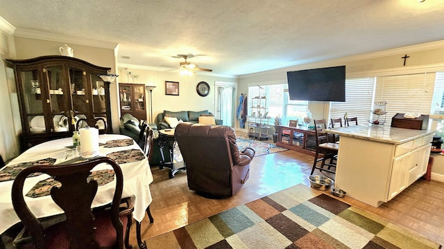 living room featuring crown molding, ceiling fan, a textured ceiling, and light parquet floors