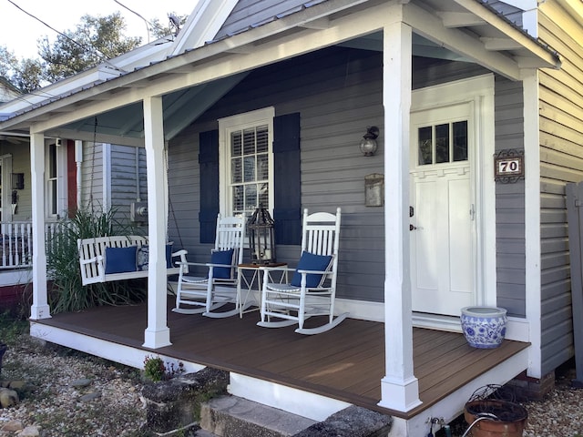 view of exterior entry featuring covered porch