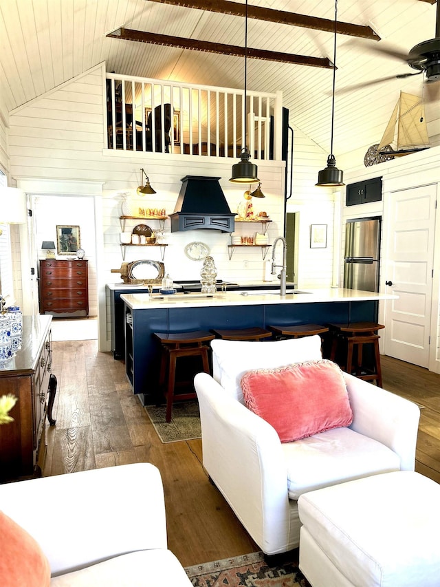 living room featuring dark hardwood / wood-style flooring, sink, high vaulted ceiling, wooden ceiling, and wood walls