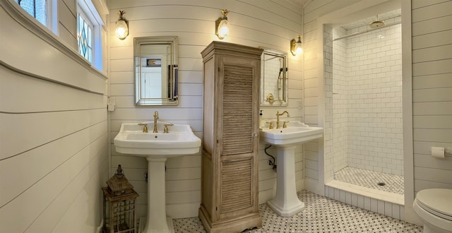 bathroom featuring toilet and a tile shower