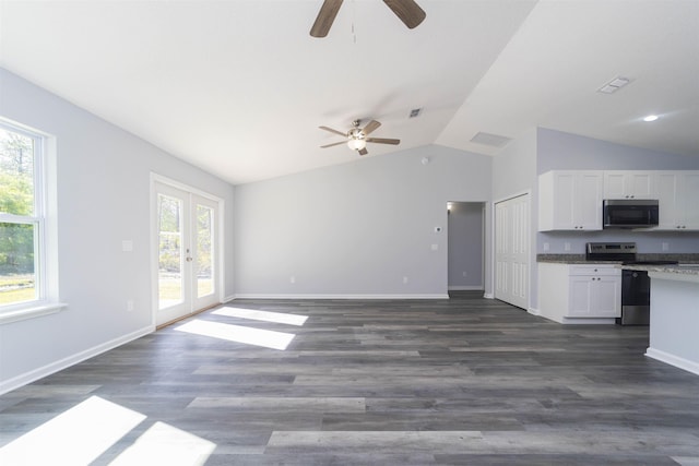 unfurnished living room with french doors, dark hardwood / wood-style floors, vaulted ceiling, and plenty of natural light