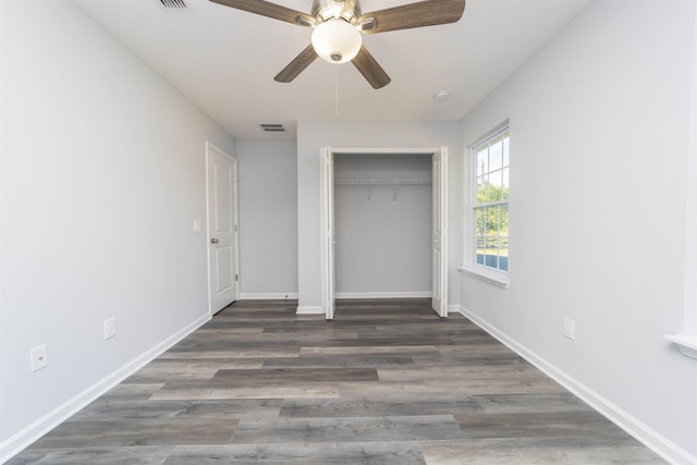 unfurnished bedroom with a closet, ceiling fan, and dark wood-type flooring